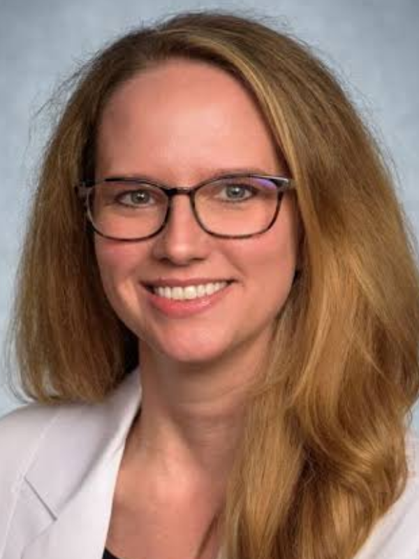 Nicole Bentley, M.D., stands in front of a gray background.