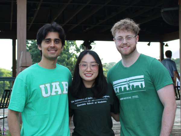 Medical students stand together smiling at a golf tournament.
