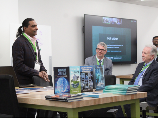 Dr. Rubin Pillay speaking in front of four published books are biomedical innovation