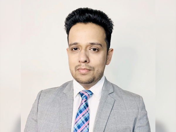 Dr. Cheema headshot with gray coat and blue patterned tie. 