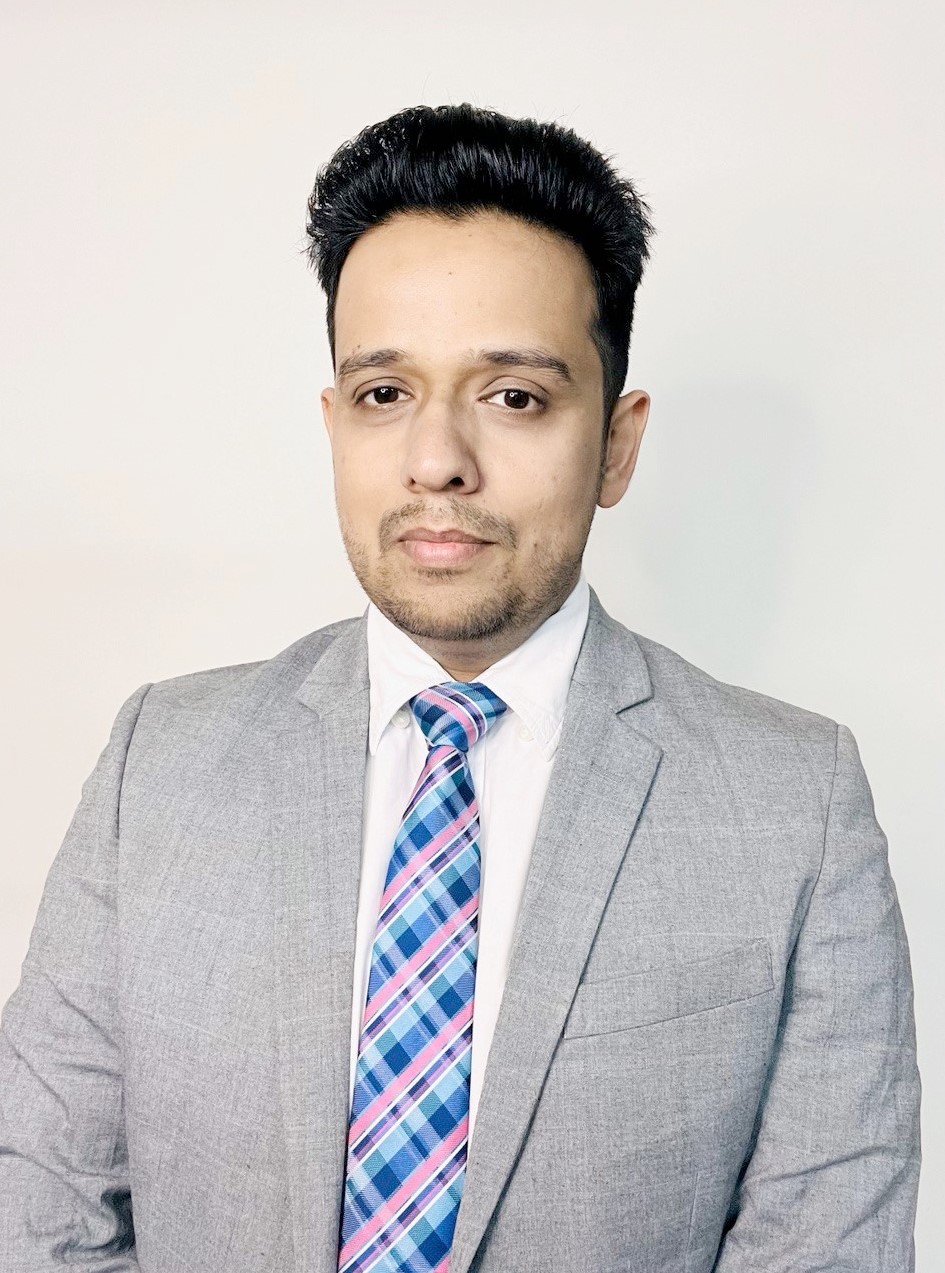 Dr. Cheema headshot with gray coat and blue patterned tie.