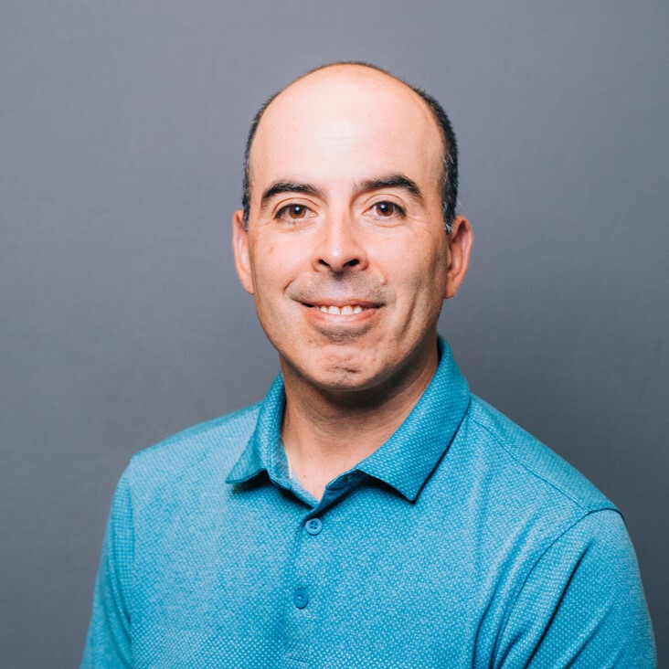 Carlos Orihuela headshot - man wearing blue polo