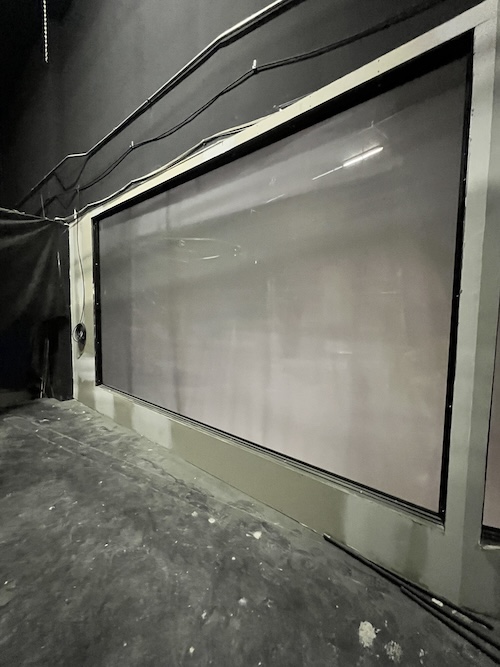 A vintage glass screen used to display projector slides.