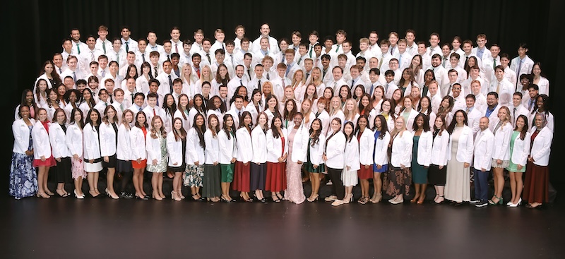 Group of students dressed in medical white coat.