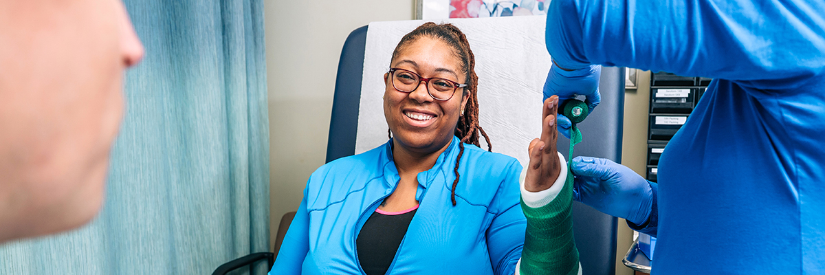 Black female doctor communicating with a patient while wearing protective face mask during medical appointment.