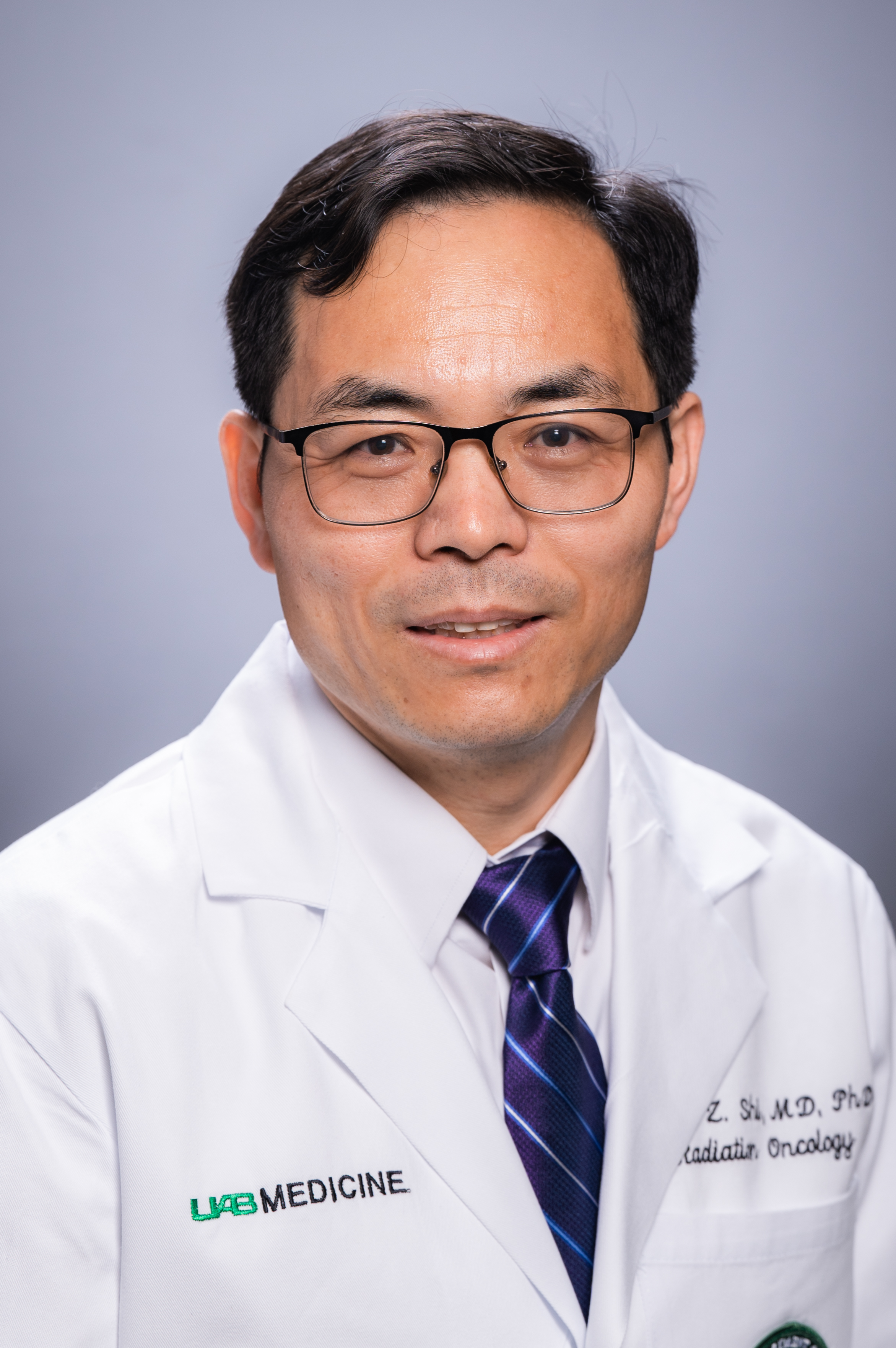 Headshot of Dr. Lewis Shi, PhD (Associate Professor, Radiation Oncology - Preclinical Research) in white medical coat, September 2022.