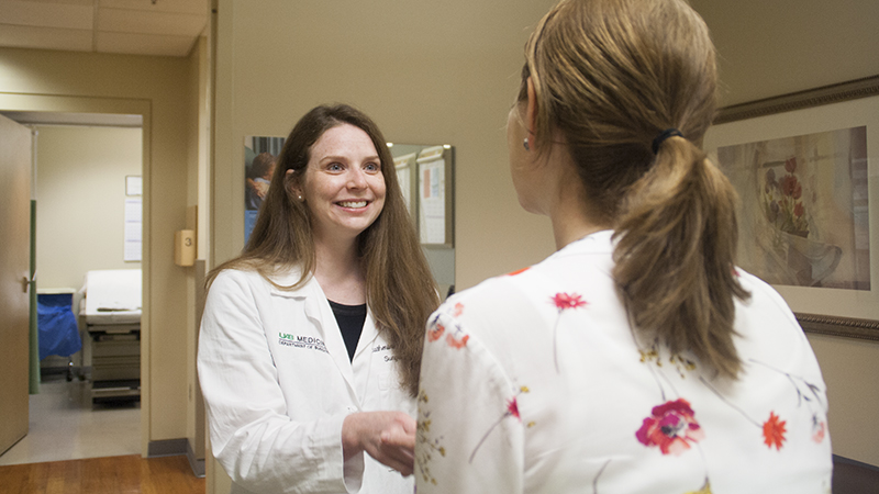 Dr. Catherine Parker, winner of the 2018 Brewer-Heslin Endowed Award for Professionalism in Medicine, talks with a patient in clinic.