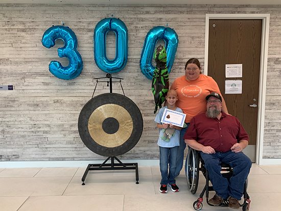 Correy Bozeman with his parents on his last day of proton therapy after ringing the Chau Gong, symbolizing end of treatment at the center