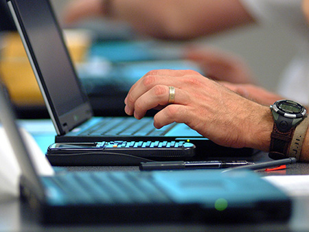 Hands typing on laptop