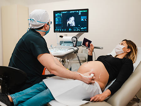 Pregnant woman watching her baby on the ultrasound