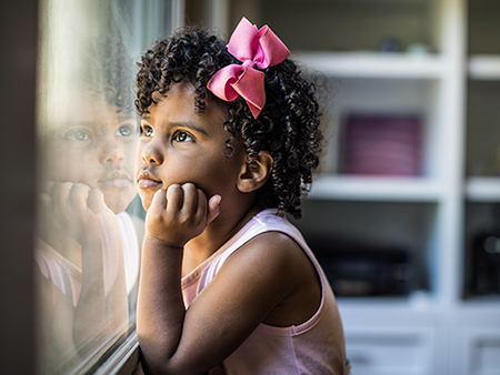 Portrait of preschool age girl looking out window