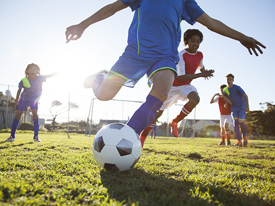 Close up action of boys soccer teams playing a soccer match