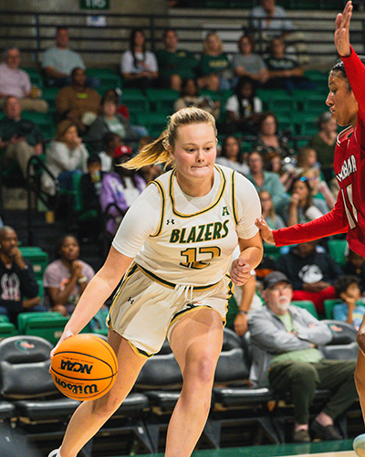 UAB women's basketball player dribbling the ball.