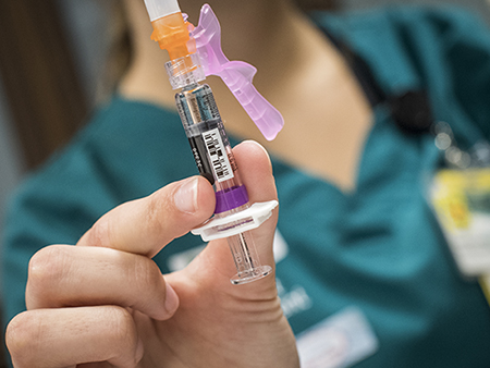 Close-up, hand holding flu vaccine applicator, 2017.