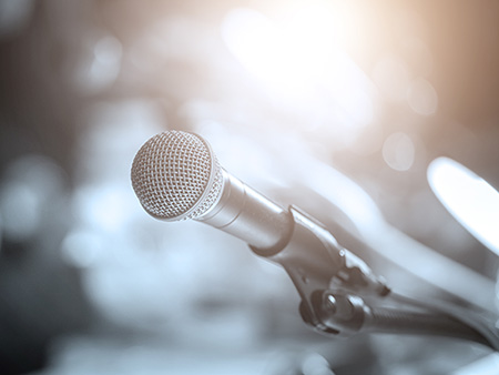 Business people talking on seminar panel with microphone