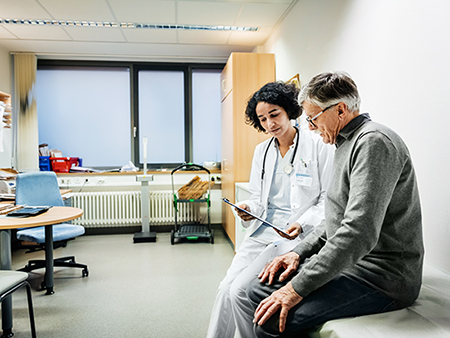 An elderly man talking to his doctor about some recent test results.