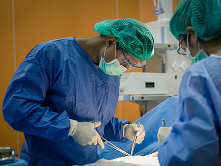 Doctor And Nurse Suture Patient In Emergency Room