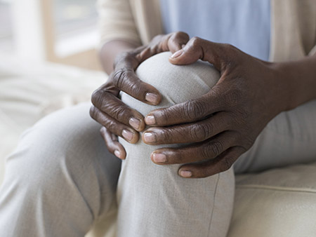 Mature woman holding sore knee.