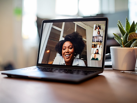 Shot of african businesswoman having a video call on a laptop with her team. Woman having meeting on video call on laptop with diverse colleagues,