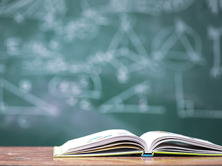 Books on table with chalkboard background in the school