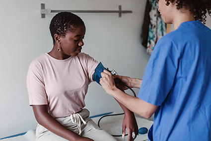 Nurse checking patient's blood pressure.