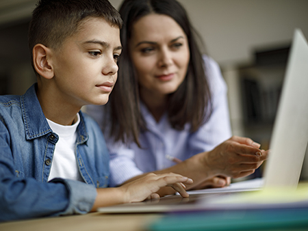 Mother an son using laptop at home