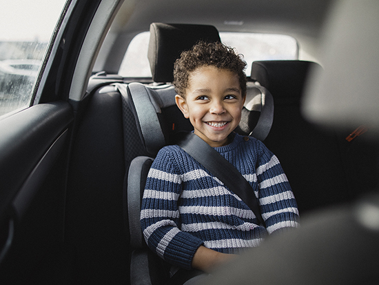 Young boy excited to be going on a car ride.