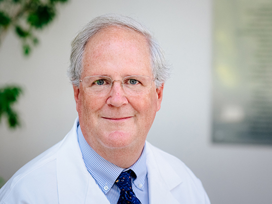 Environmental headshot of David Standaert, MD (Professor/Chairman, Neurology) in white medical coat, 2019.