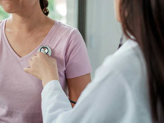 Doctors are using a medical stethoscope to check patient's heart.