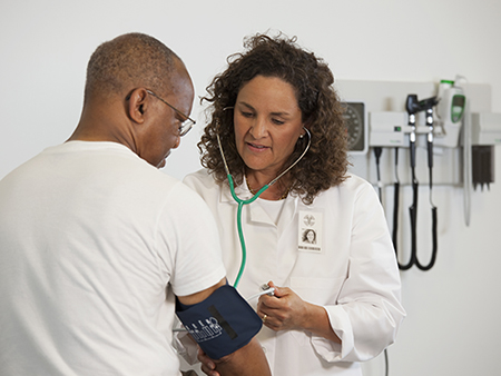 Female doctor checking male patient's blood pressure. 