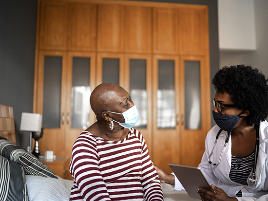 Health visitor and a senior woman during nursing home visit. 