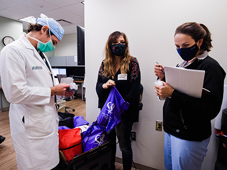 Bishop, Dr. Eudailey and Abbey Barrow look at all the items in the care packages. 