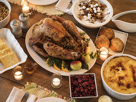 High angle view of extended family communicating while having Thanksgiving dinner at dining table.