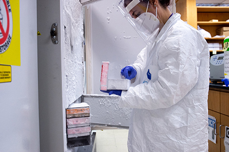 Healthcare worker in PPE working in lab.