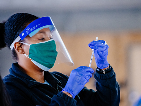 Healthcare worker preparing COVID-19 vaccine.