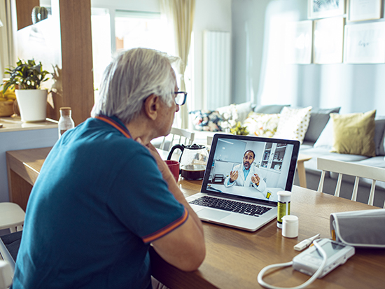 Close up of a senior man consulting with a doctor on his laptop