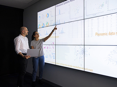 Discussion in front of a large information device about universal detection of genes in a specific biological sample.