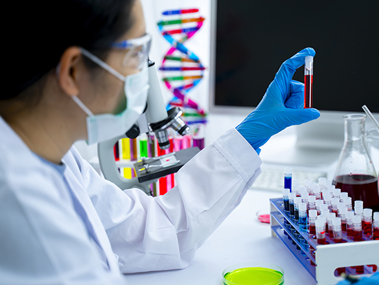 Researcher looking at blood sample in lab. 