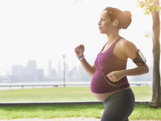 Pregnant mixed race woman power walking in park