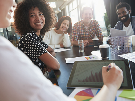 Over the shoulder shot of a group of business colleagues in a meeting around a conference table