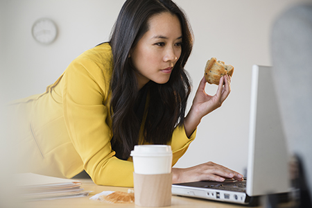 Mixed race businesswoman stretching at desk