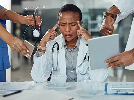 Shot of a doctor looking stressed out in a demanding work environment