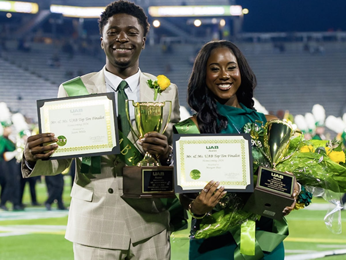 Two students smile at a football game.