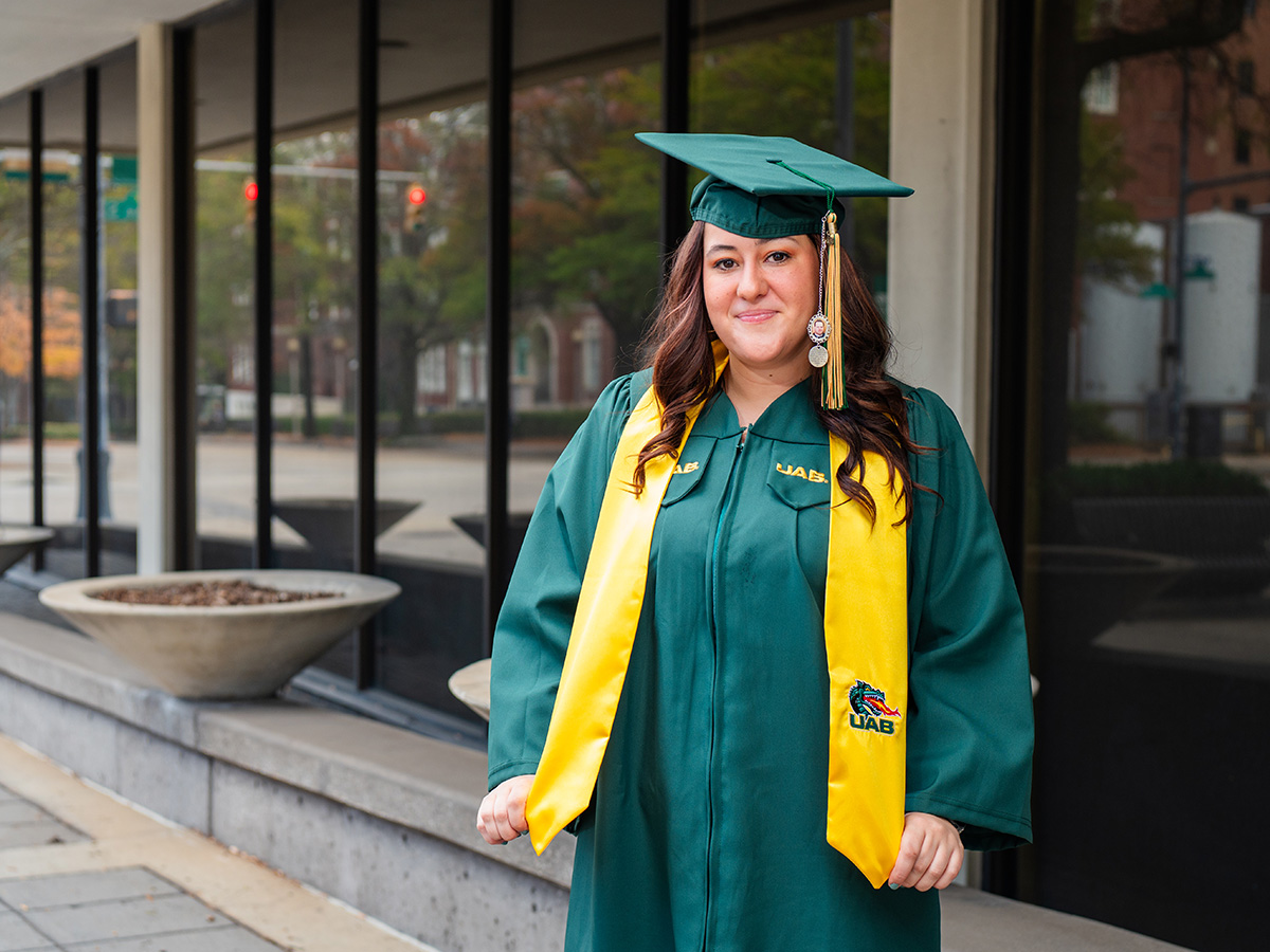 Alexis in her commencement regalia in front of the Administration Building on UAB's campus. 