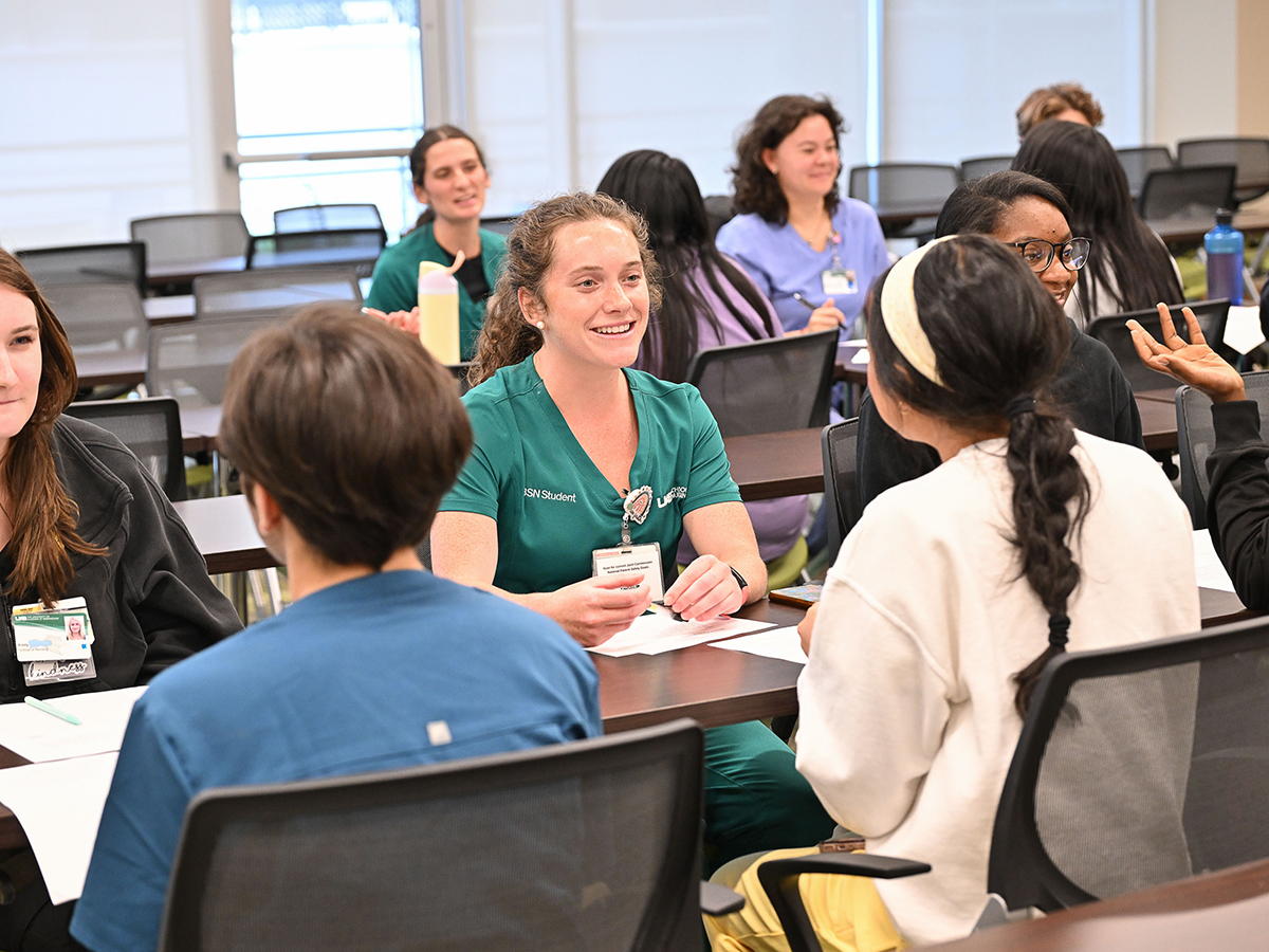 Nursing students wearing scrubs, in a classroom