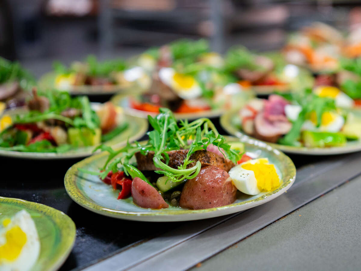 Close-up of plated salads, prepared from Frank Stitt recipe, are displayed on cold food table in The Commons on the Green, October 2025.