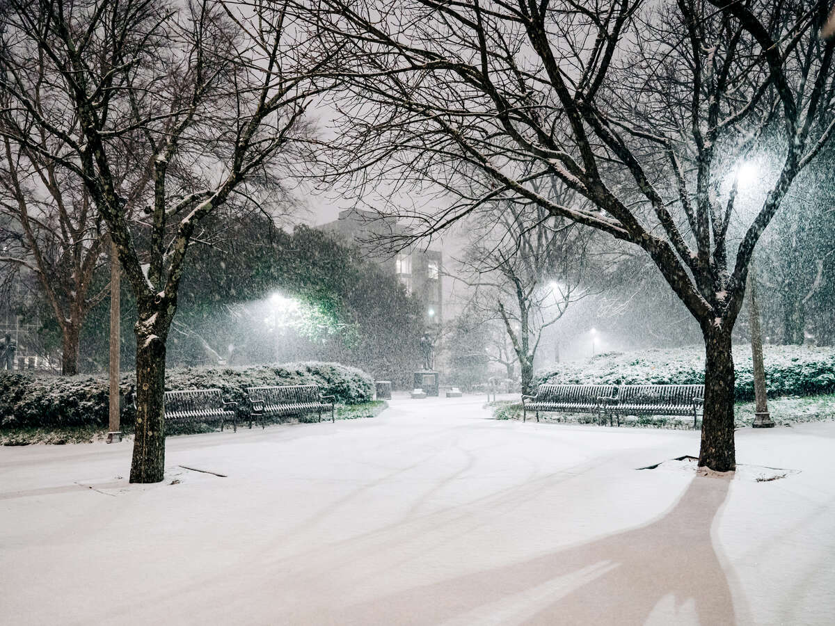 UAB Mini Park covered with snow during an active snowfall at dawn.