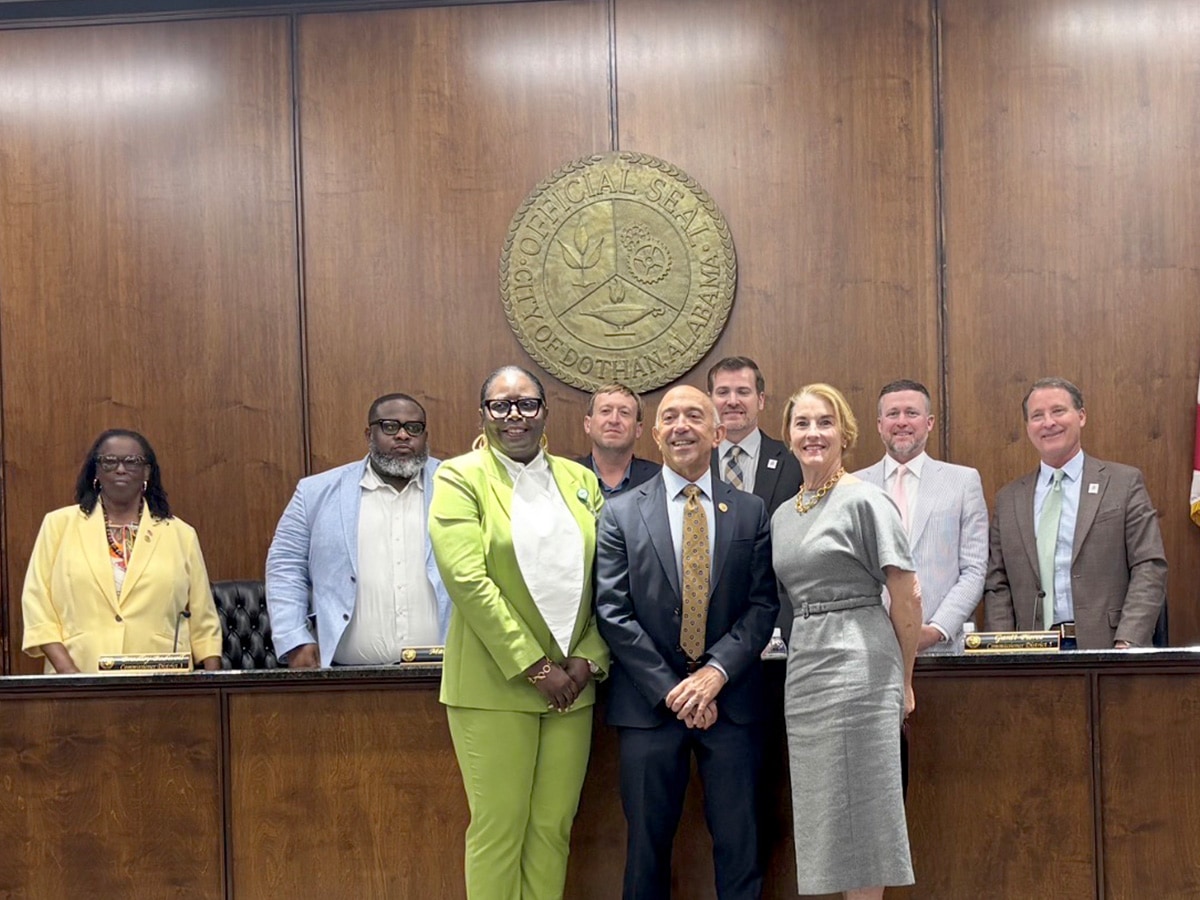 Group photo in front of the official seal of Dothan, Alabama including Dothan mayor, Mark Saliba, Live HealthSmart Alabama team members Teresa Shufflebarger and Thamar Taylor standing in front of Dothan city council members. 