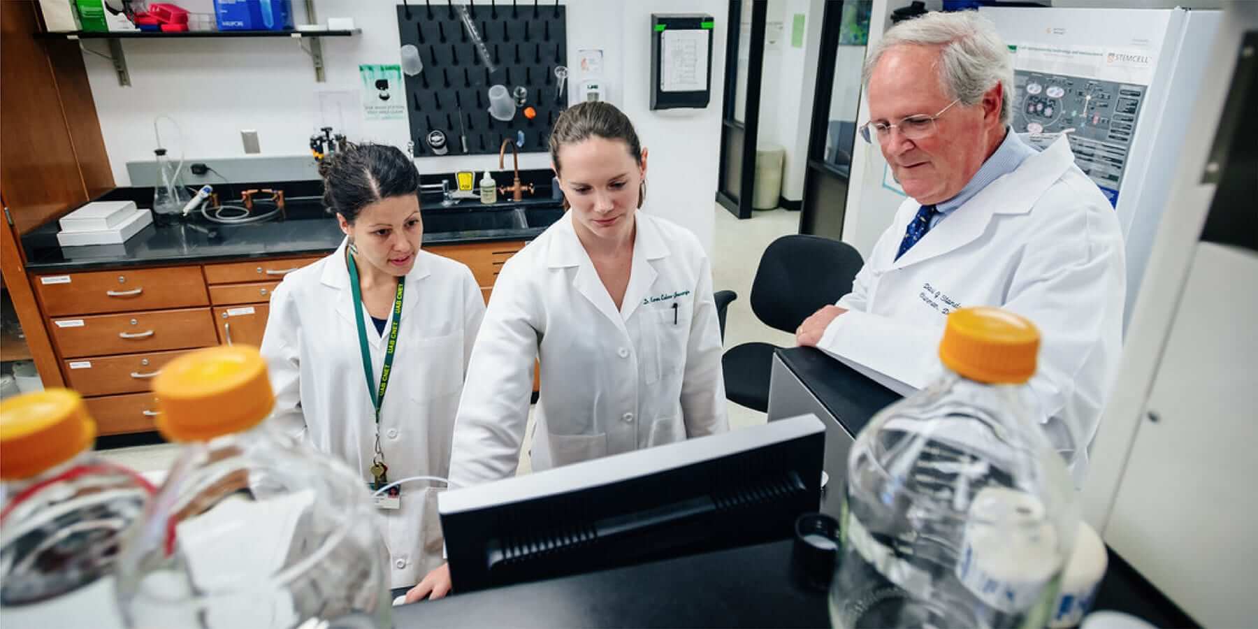 A mentor and two postdocs in a research lab. 