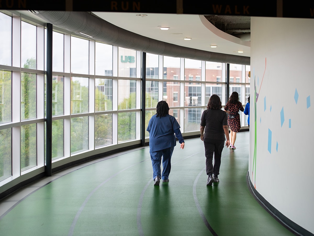 Employees walk on the indoor track at the Campus Rec Center